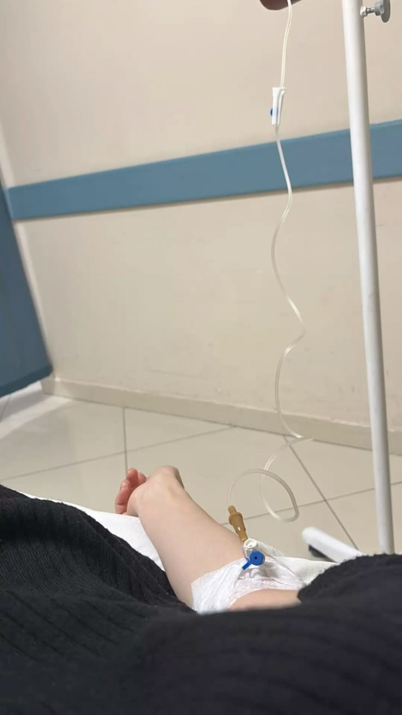 ảnh truyền nước ở tay nữ với tay đặt trên giường